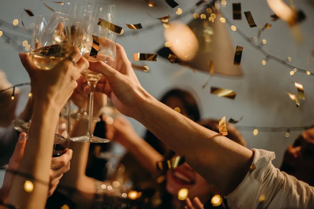 Guests raising gold-lit champagne glasses at a celebration